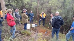 People standng around trapper Eddie Juras as he demonstrates setting soft jaw traps