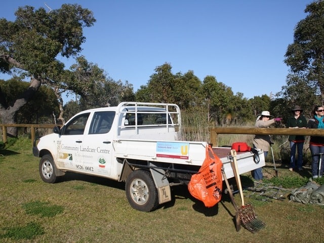 ute and 3 people in front of bushland