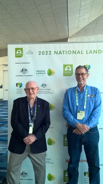 two men standing in fron of Landcare poster
