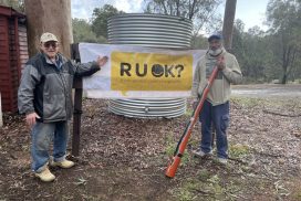 two men standing in front of an RUOK banner